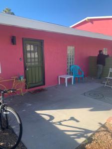 a red building with a green door and a table and a blue chair at Casada in Las Vegas