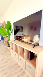 TV de pantalla plana grande en un centro de entretenimiento de madera en Panorama Lodge, en Salzgitter 21 fotos más