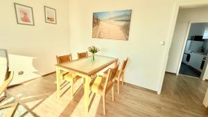 a dining room table with chairs and a vase of flowers on it at Panorama Lodge in Salzgitter
