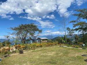 a field of flowers with a house in the background at The Nest Farmhouse in Sāmthar