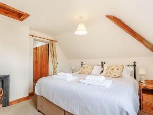 a bedroom with a large bed with white sheets at Robin's Nest in Craven Arms