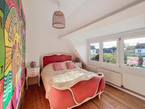 a bedroom with a bed and a large window at Le Blériot in Sangatte