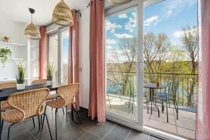 Una habitación con balcón con mesa y sillas. en Superbe T3 avec vue imprenable sur le Rhône, en Caluire-et-Cuire