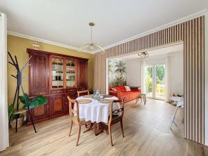 a dining room with a table and a couch at Le Blériot in Sangatte