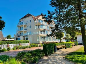 a large white apartment building with a bench in front of it at Ferienwohnung Strandliebe Laboe in Laboe