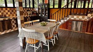 a dining room with a table and chairs in a kitchen at Charming Nature Kampung Home for Family Getaways in Benta
