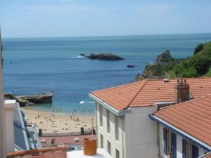 Una vista de una playa con gente en el agua. en Hôtel Les Alizés, en Biarritz