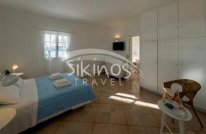 a bedroom with a bed and a table and chairs at Beachfront Cycladic House in Chora Folegandros