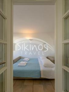 a bed in a room with a sign that reads skilles travel at Beachfront Cycladic House in Chora Folegandros