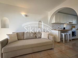 a living room with a couch and a kitchen at Beachfront Cycladic House in Chora Folegandros