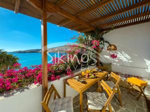 a patio with a table and chairs and flowers at Beachfront Cycladic House in Chora Folegandros