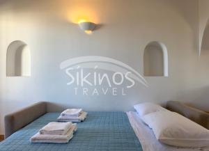 a room with two beds and a sign that says skilles trance at Beachfront Cycladic House in Chora Folegandros
