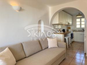 a living room with a couch and a kitchen at Beachfront Cycladic House in Chora Folegandros