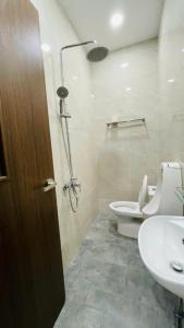 a bathroom with a shower and a toilet and a sink at La La Homestay Phu Quoc in Phu Quoc