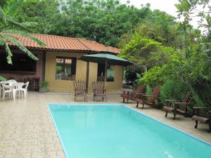 een zwembad met stoelen en een parasol naast een huis bij Eco Pousada Villa Verde in Bonito