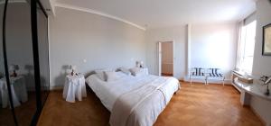 a white bedroom with a large bed with white sheets at VELOCIPEDE OUDENAARDE vakantieverblijf 6 pers in Oudenaarde