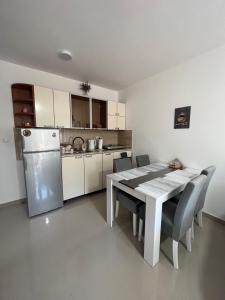 a kitchen with a table and chairs and a refrigerator at Apartman Miletic in Ostrovo
