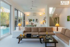 a living room with a couch and a table at StayVista at Villa Magnifica - Private Pool, Wi-Fi in Mandrem