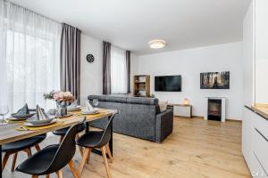a living room with a table and a couch at KORZO LIPNO C in Lipno nad Vltavou