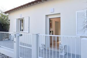 a white house with a balcony with a door at Renovated villa 400 meters from the sea with garden in Forte dei Marmi