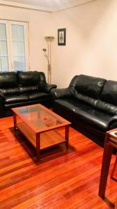 a living room with a black leather couch and a coffee table at Balcón de San Lorenzo in Ezcaray +5 photos