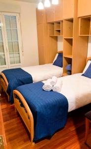 a room with three beds with blue sheets at Balcón de San Lorenzo in Ezcaray