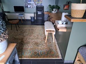 a living room with a bench on a rug at Middelpunt Opmeer in Opmeer