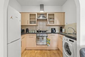 eine Küche mit einem Herd, einer Waschmaschine und einem Trockner in der Unterkunft 2 Bedroom flat for Cntractors,Workers,Relocation,Insurance,Family, Guidford st in Luton