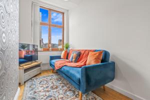 ein blaues Sofa im Wohnzimmer mit einem TV in der Unterkunft 2 Bedroom flat for Cntractors,Workers,Relocation,Insurance,Family, Guidford st in Luton