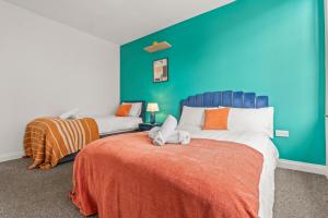 ein Schlafzimmer mit zwei Betten und einer blauen Wand in der Unterkunft 2 Bedroom flat for Cntractors,Workers,Relocation,Insurance,Family, Guidford st in Luton