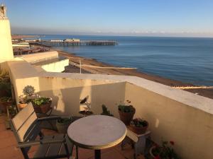 a table and chairs on a balcony overlooking the ocean at Seafront balcony, lovely spacious relaxing flat in Hastings