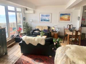 a living room with two couches and a table at Seafront balcony, lovely spacious relaxing flat in Hastings