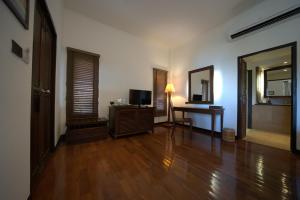 a living room with a table and a television and a mirror at Ao Prao Resort in Ko Samed