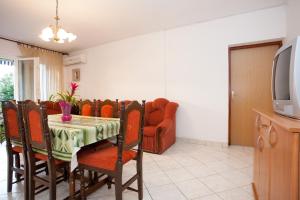 a dining room with a table and a couch at Two Bedroom Apartment Sonja with Seaview in Punat