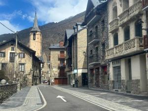 an empty street in a town with a church at Winahost Apartamento Temporal Esterri d'Àneu in Esterri d'Àneu