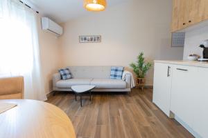 a living room with a couch and a table at Bright & Cozy Apartment in quiet area near Airport in Golubovci