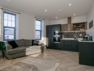 a living room with a couch and a kitchen at Dwell Living North Bridge Apartments in Sunderland