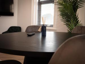 a table with a remote control and a vase on it at Dwell Living North Bridge Apartments in Sunderland