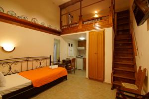 ein Schlafzimmer mit einem Bett und einer Treppe in einem Zimmer in der Unterkunft Kostia Studios in Skyros