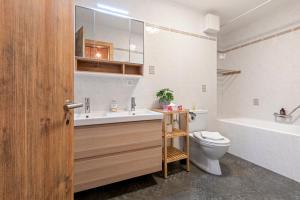 ein Badezimmer mit Waschbecken, Toilette und Badewanne in der Unterkunft Appartement avec terrasse, proche du centre in Crans-Montana