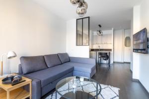 a living room with a couch and a table at Charmant appartement proche de Paris in Vincennes