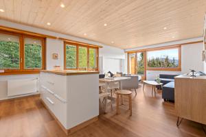 eine Küche und ein Wohnzimmer mit Tisch und Stühlen in der Unterkunft Appartement avec terrasse, proche du centre in Crans-Montana