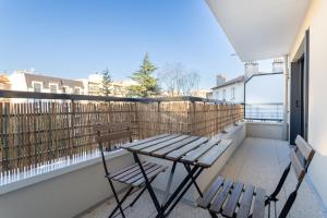 a balcony with two chairs and a wooden table at Charmant appartement proche de Paris in Vincennes +3 photos