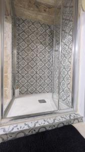 a shower with a glass door in a bathroom at Valletta Authentic Apartment in Valletta