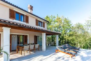 a patio of a house with chairs and a table at House Andrijasi in Žminj