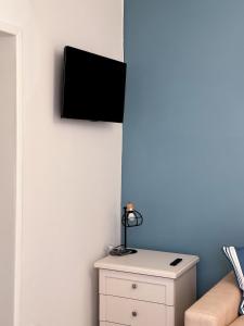 a tv on a wall next to a white cabinet at Renovated house 400 meters from the sea with parking in Forte dei Marmi
