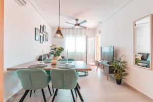a dining room and living room with a table and chairs at Design Seascape apartment in Orihuela Costa