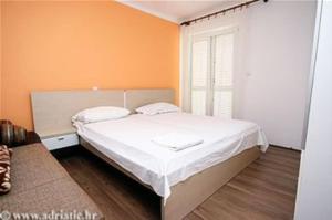 a bedroom with a white bed and a window at Anka Studios in Vrbnik