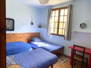 a room with two beds and a window at Valfregue, grande maison familiale in Le Vigan