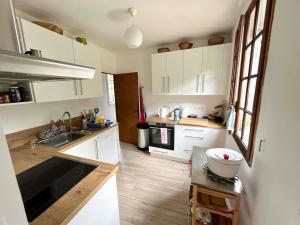 a kitchen with white cabinets and a sink at Valfregue, grande maison familiale in Le Vigan +33 photos